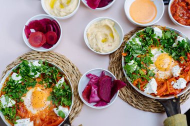 Shakshuka, kızarmış yumurta, domates soslu masada