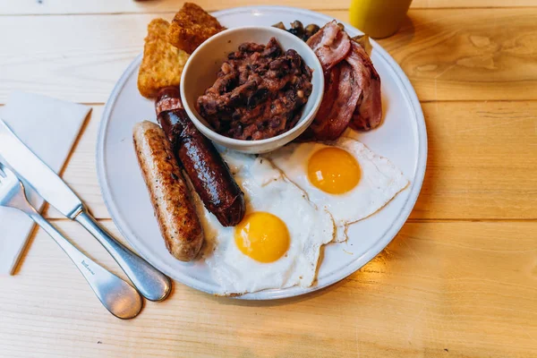 Petit déjeuner avec bacon, saucisse, oeuf, haricots et champignons — Photo