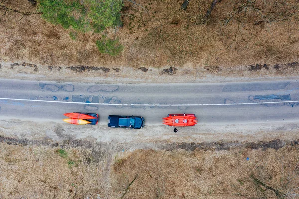 Several cars with kayaks on roof rack driving on the road among trees — Stock Photo, Image