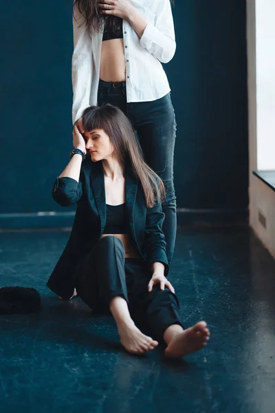 Zwei Mädchen posieren für die Kamera, eines steht, das andere auf dem Boden — Stockfoto