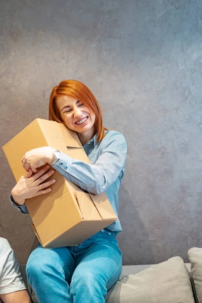 Mujer joven sosteniendo cajas de cartón y lo sacude — Foto de Stock