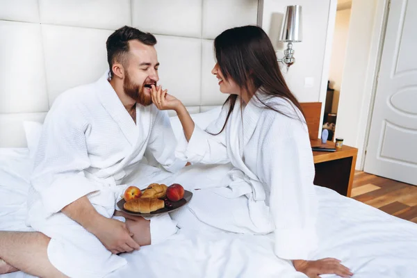 Der Kerl und das Mädchen Bademantel, Mädchen füttert den Kerl Obst — Stockfoto