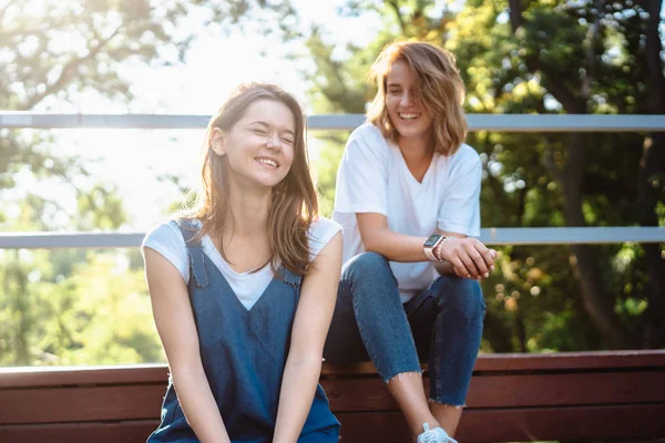 Dwie piękne, młode kobiety spoczywające na ławce — Zdjęcie stockowe