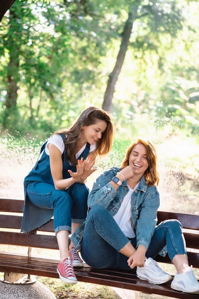 Dwie piękne, młode kobiety spoczywające na ławce — Zdjęcie stockowe