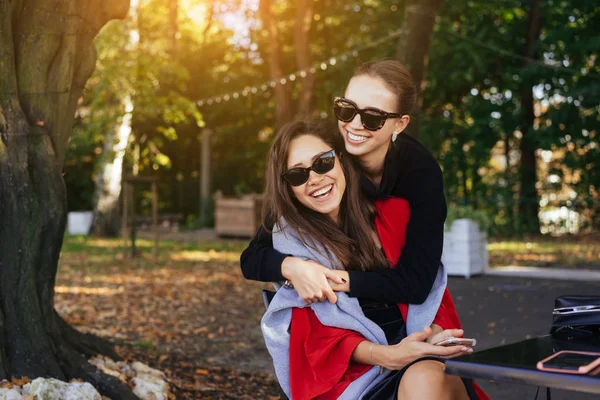 Rapariga a abraçar a amiga. Retrato Duas namoradas no parque . — Fotografia de Stock
