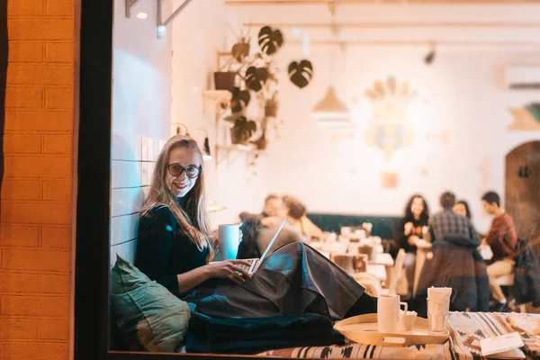 Woman works at a cafe in the evening — Stock Photo, Image