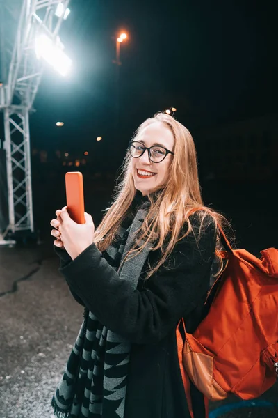 Mulher loira com smartphone à noite na rua . — Fotografia de Stock