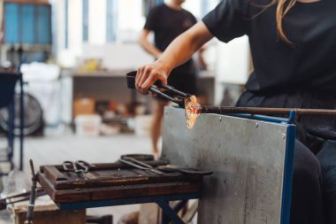 Cam üfleyen bir öğrenci camdan çiçek yapmaya çalışır.