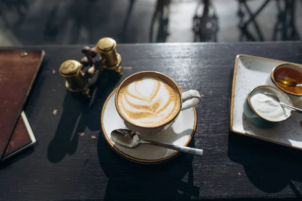 Кофе в белой кружке с листовым дизайном — стоковое фото