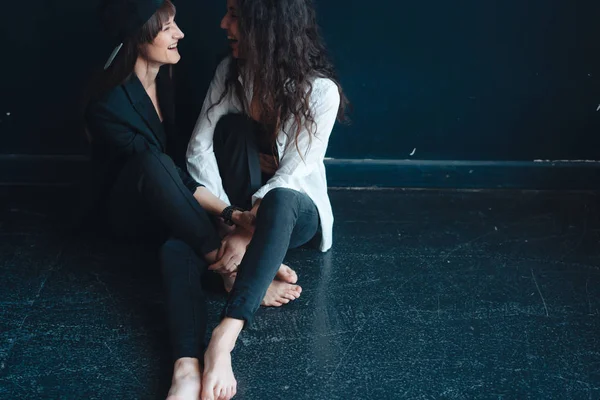 Meninas bonitas sentar na parede e posar — Fotografia de Stock