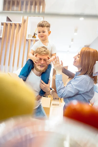 Pai mãe e pequeno filho jogar no quarto com caixas de papel — Fotografia de Stock