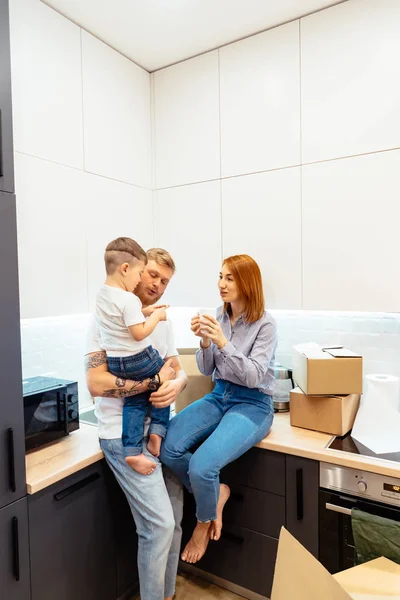 Joven familia desempacando cajas en nuevo hogar — Foto de Stock