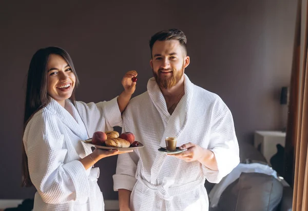 Killen och tjej badrocken, flicka matar killen frukt — Stockfoto