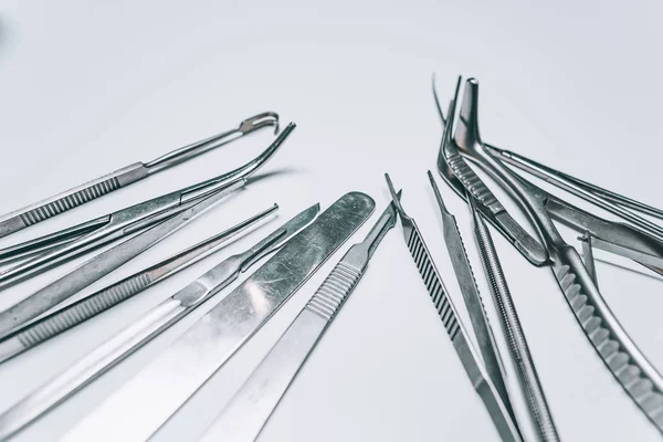 Flera kirurgiska instrument ligger på ett vitt bord — Stockfoto
