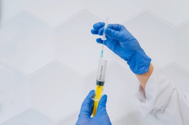 Lastik eldiven elinde bir tek kullanımlık tıbbi şırınga uyuşturucu ile tutun