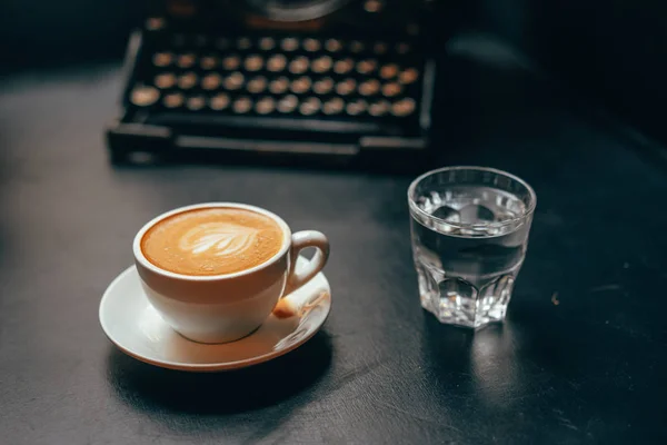 Чашка кофе латте в керамической чашке и стакан воды — стоковое фото