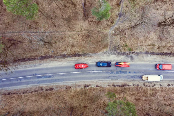 Mehrere Autos mit Kajaks auf Dachgepäckträger fahren auf der Straße zwischen Bäumen — Stockfoto