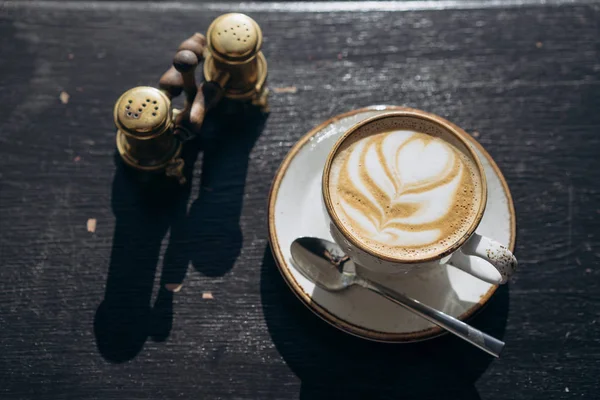 Coffee shop coffee in a white mug with a leaf design — Stock Photo, Image