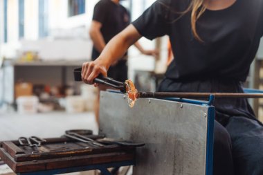 Cam üfleyen bir öğrenci camdan çiçek yapmaya çalışır.