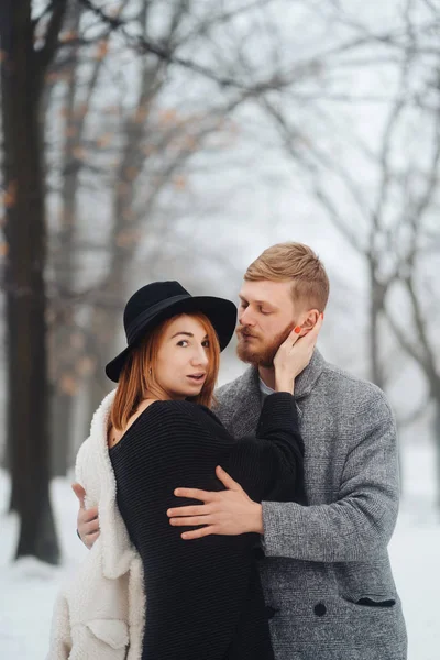 Killen och tjejen vilar i skogen vinter. — Stockfoto