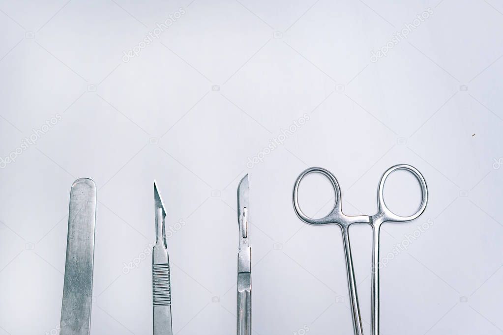 Scapula for throat, two scalpels and clamp on a light background