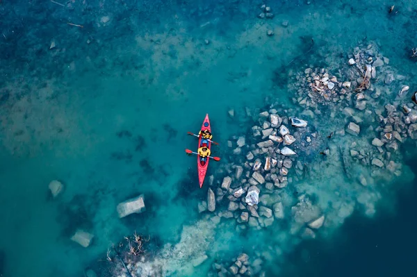 Deux hommes athlétiques flottent sur un bateau rouge dans la rivière — Photo