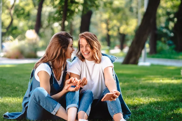 Upřímní přátelé seděli v parku a povídali si.. — Stock fotografie