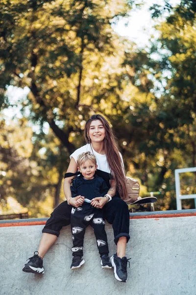 Красивая молодая хипстерская мама и маленький сын в скейтпарке — стоковое фото