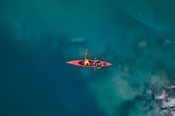 Два спортсмена плавают на красной лодке в реке — стоковое фото