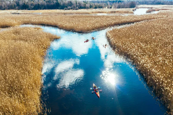 Group of people in kayaks among reeds on the autumn river. — Stock Photo, Image