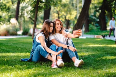 Parkta oturan iki kadın arkadaşım var bir selfie almak bir dinlenme