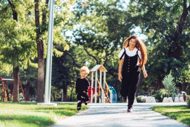 Anne ve küçük oğlu parkta yürüyorlar.