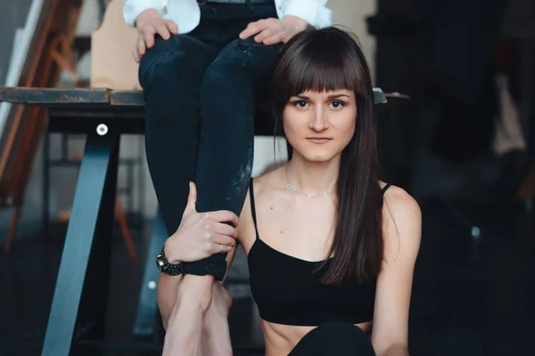 Duas meninas estão posando para a câmera, uma sentada em uma mesa, outra no chão — Fotografia de Stock