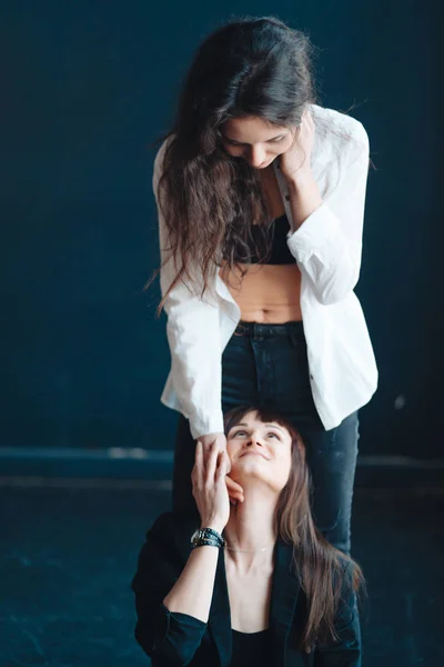 Duas meninas estão posando para a câmera, uma de pé, outra no chão — Fotografia de Stock