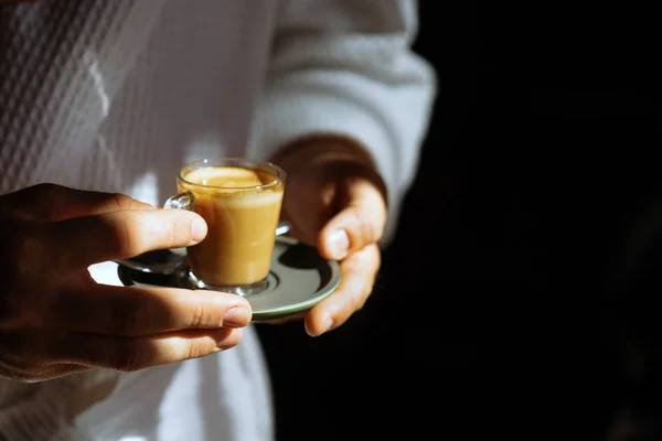 A man in a bathrobe is holding a small mug of coffee — Stock Photo, Image