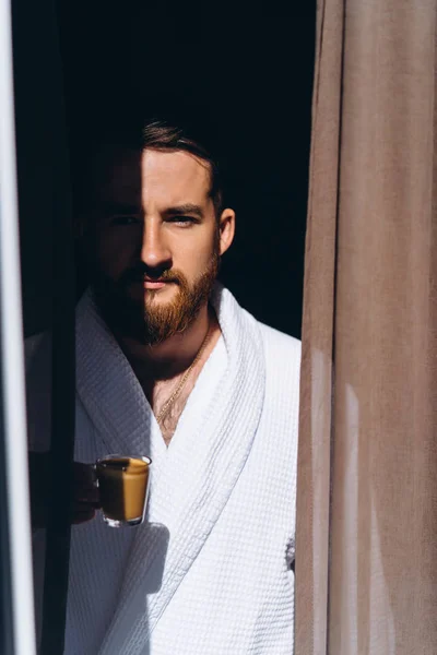 Male in white bathrobe with coffee mug in hand. — Stock Photo, Image