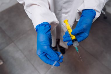 Lastik eldiven elinde bir tek kullanımlık tıbbi şırınga uyuşturucu ile tutun