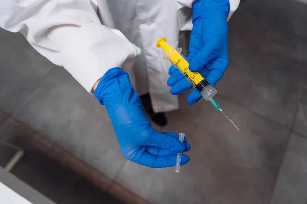 Mani in guanti di gomma tengono una siringa medica usa e getta con il farmaco — Foto Stock