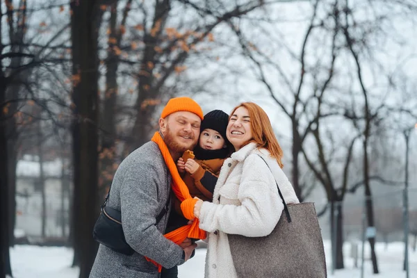 Papá mamá y el bebé en el parque en invierno —  Fotos de Stock
