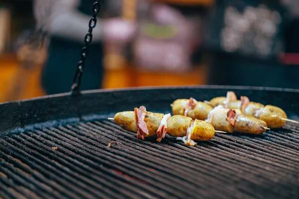 Batata com bacon em espetos cozidos na fogueira — Fotografia de Stock