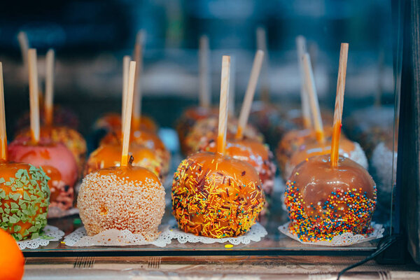 Apples in caramel and sprinkles. Street food.