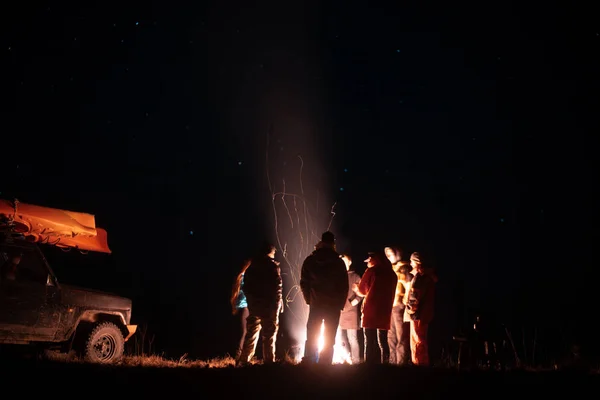 快乐的朋友在篝火周围一起休息 — 图库照片