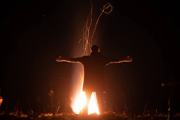 一个男人张开双臂站在火炉前 — 图库照片