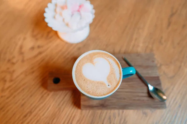 Café quente latte em uma xícara verde com arte latte — Fotografia de Stock