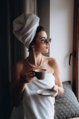 Kahve içme duştan sonra bir havlu ile sarılmış kız