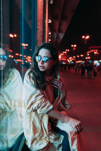 Noite na cidade, mulher bonita entre luzes vermelhas. — Fotografia de Stock