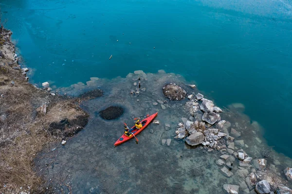 Dois atletas flutuam em um barco vermelho no rio — Fotografia de Stock