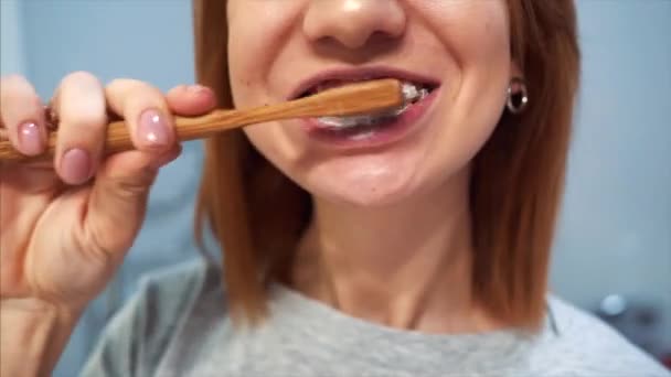 Pretty young woman in the bathroom brushing her teeth — Stock Video