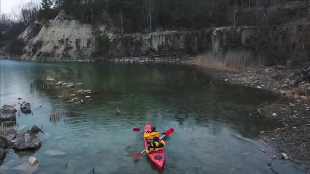 Dois atletas flutuam em um barco vermelho no rio — Vídeo de Stock