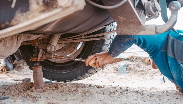 Un hombre levanta en un jack 4x4 fuera del camión de carretera — Foto de Stock